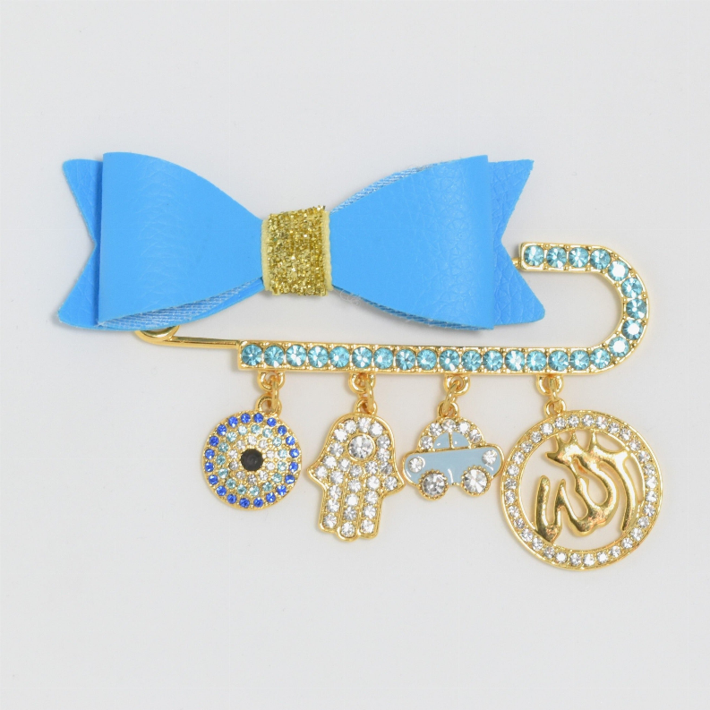 Baby pin set with blue bow, gold-tone pin, and dangling round and hand charms
