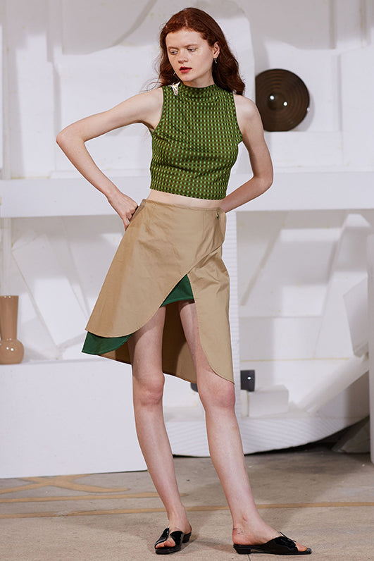 Tan high-front slit skirt with green underpanel at asymmetrical opening