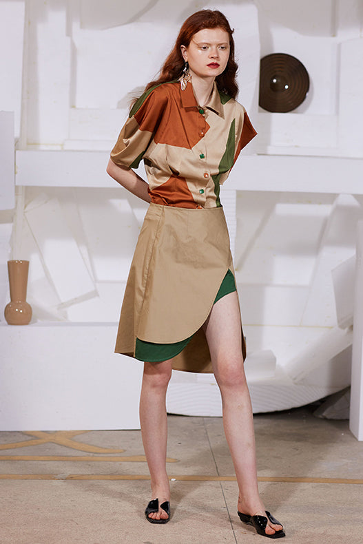 Tan asymmetrical skirt with high-front open slit and green contrast insert