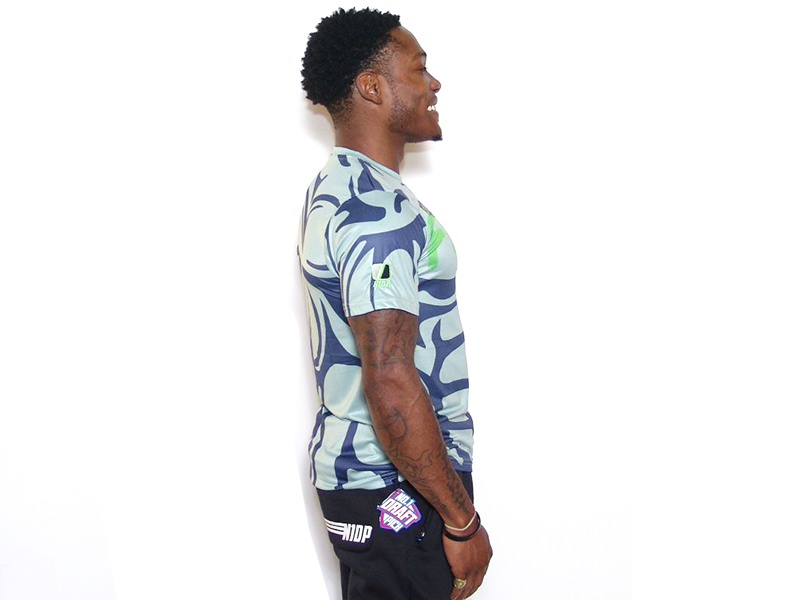 Men's graphic T-shirt side view with blue abstract pattern and green accent logo, crew neck