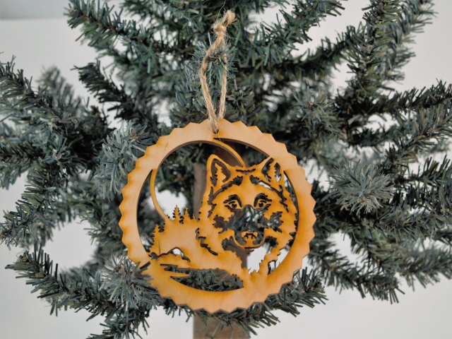 Unfinished wood tree ornament with lone wolf and forest scene, round cutout