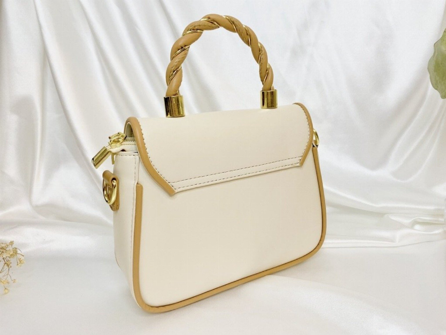 Small cream handbag with braided handle, gold square lock clasp, and front flap.