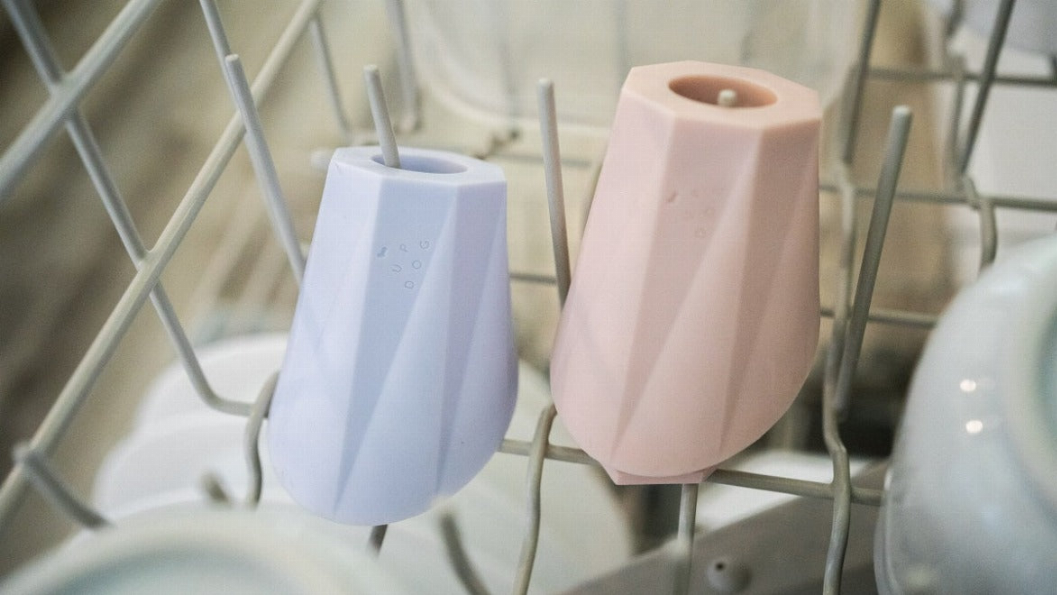 Pair of treat filler chew toys in light blue and pale pink, standing on dish rack