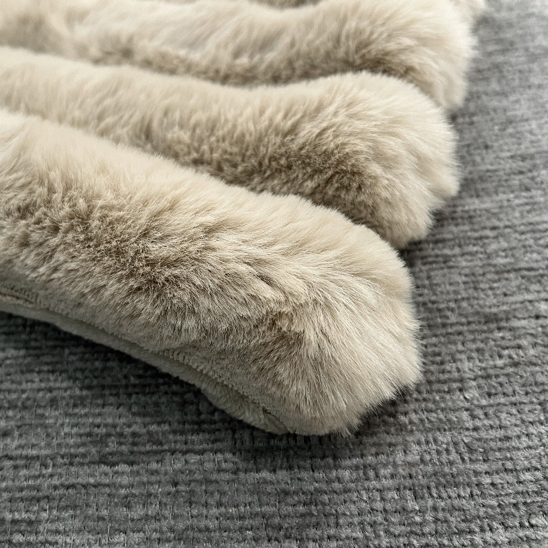 Puffy faux fur throw blanket with thick light gray faux fur trim on textured backing
