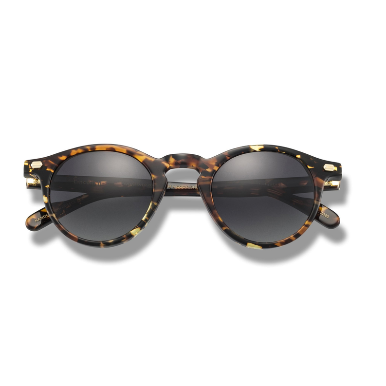 Tortoise round sunglasses with dark tinted lenses and gold-tone hinges