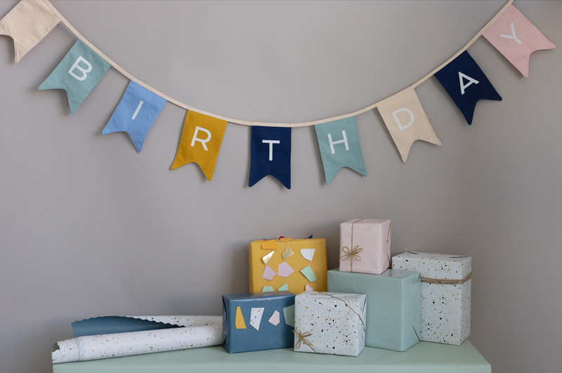 Two-sided terrazzo gift wrap with wrapped boxes and letter bunting on display