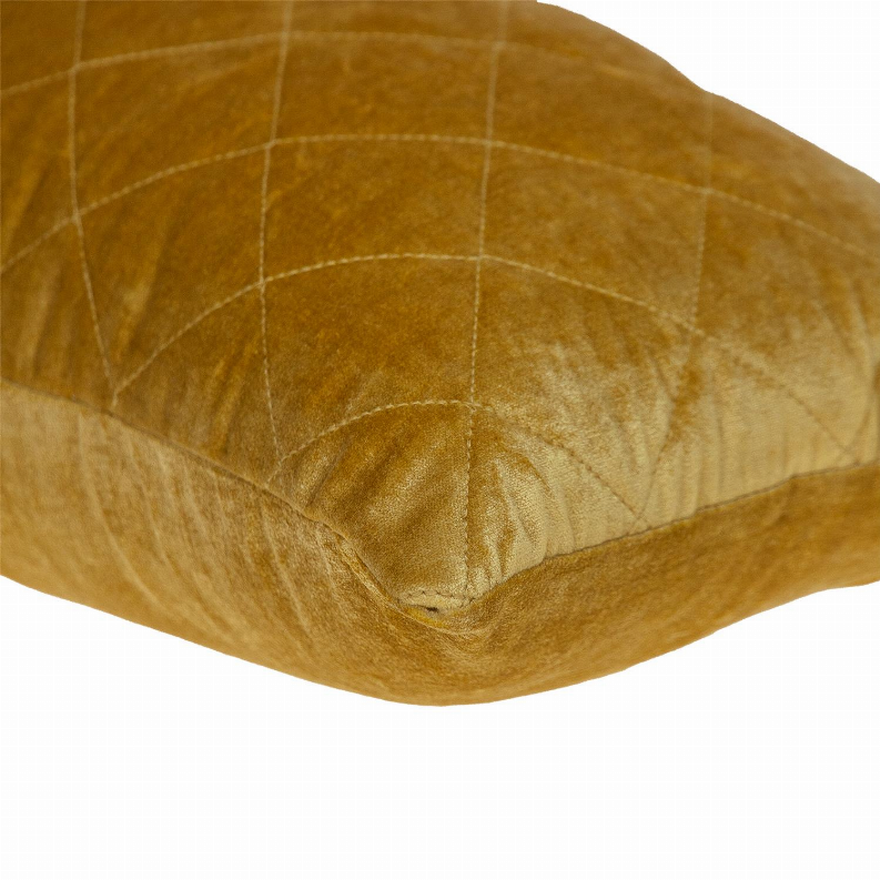 Close-up of gold quilted pillow fabric with diamond stitching and velour texture