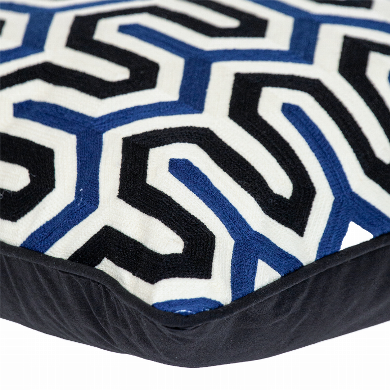 Square pillow corner close-up with blue-and-white zigzag pattern on dark trim