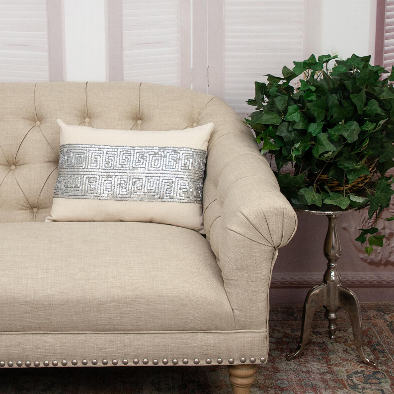 Cream decorative pillow with blue-gray embroidered center stripe on sofa