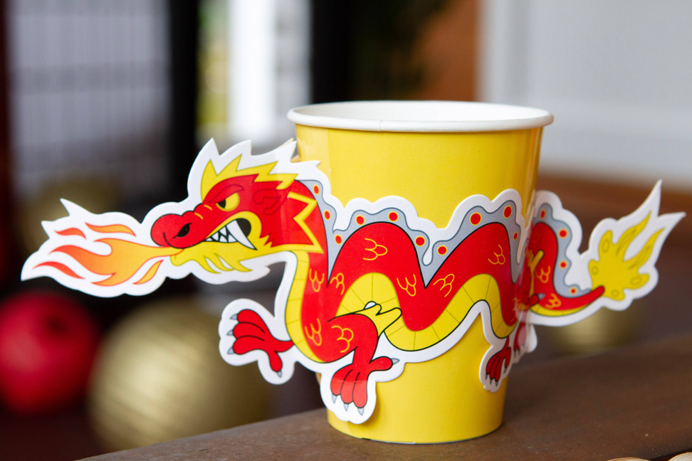Yellow paper cup with large red dragon sleeve-style graphic and white rim
