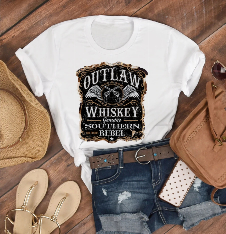 White graphic T-shirt with large black skull and outlaw whiskey emblem on chest
