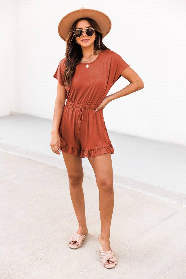 Rust terracotta short-sleeve romper with drawstring waist and ruffle hem