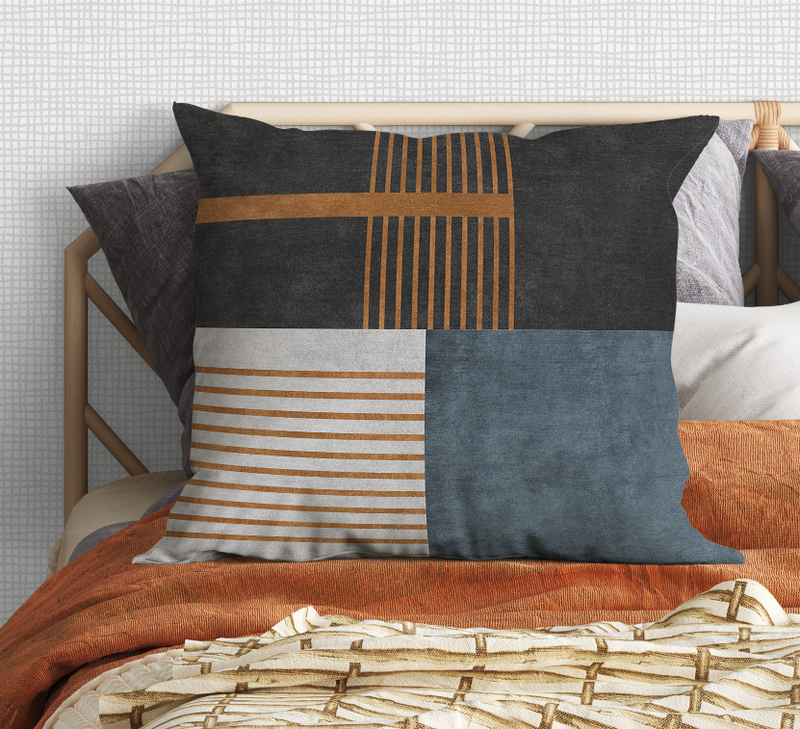 Decorative pillow with charcoal square blocks, tan stripes, and denim-blue panel