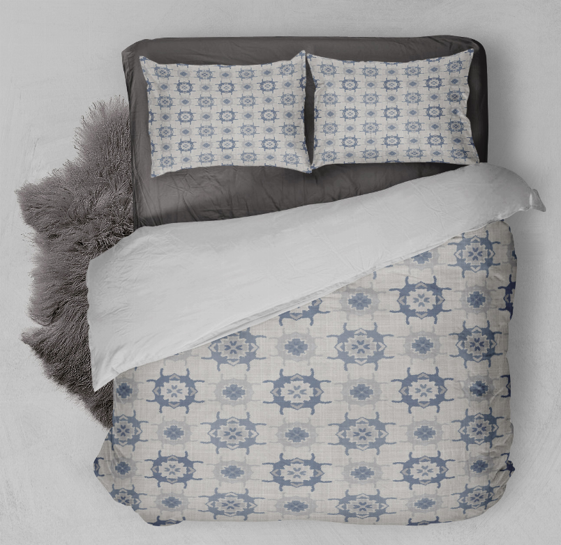 Blue geometric comforter with matching pillow shams, laid on the bed