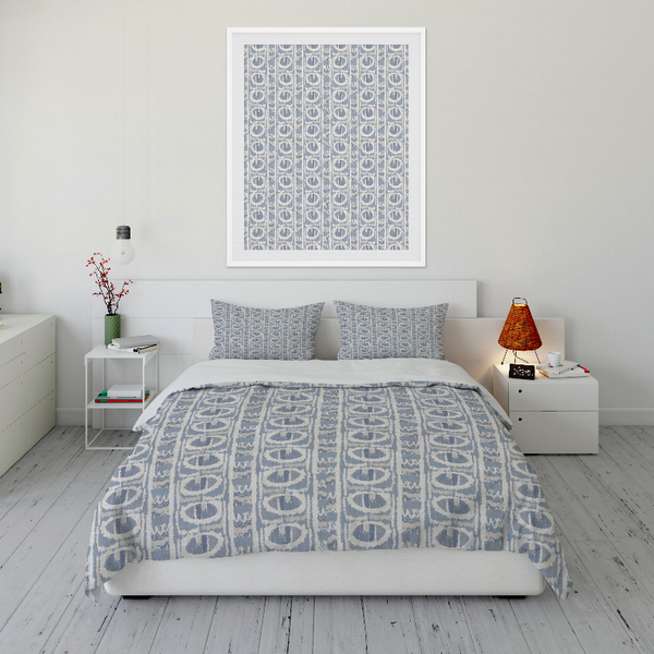 Blue patterned duvet cover with matching pillow shams, folded on bed