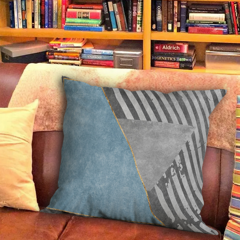 Multi-color square throw pillow with blue fabric, grey striped corner, and diagonal grey triangle