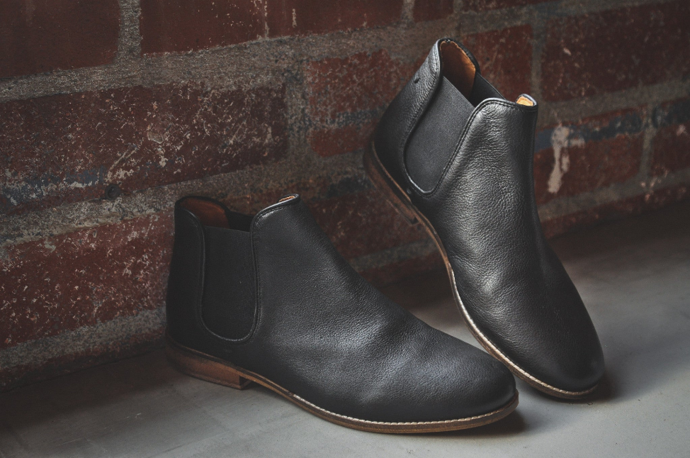 Black leather Chelsea boots, side view, elastic gore and tan interior