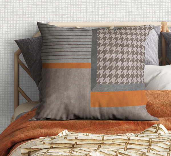 Patchwork throw pillow with gray stripes, houndstooth, and orange bands