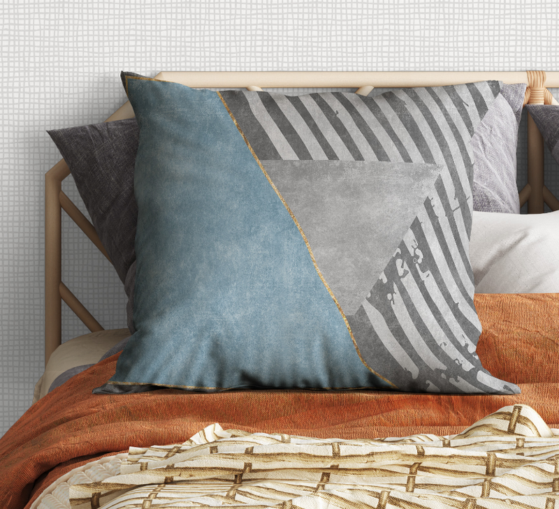 Geometric throw pillow with blue center, gray striped panel, and gray triangular corner