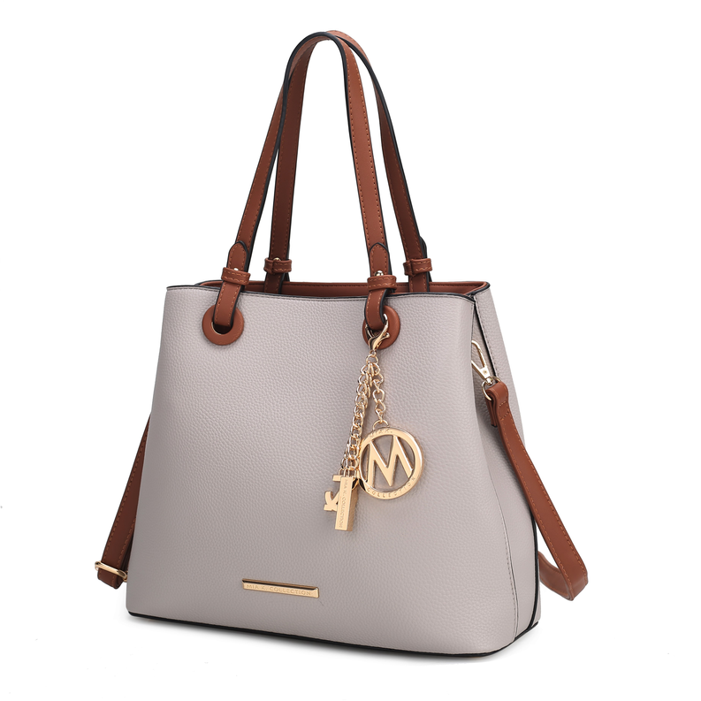 Light gray tote bag with brown leather handles, gold hardware, and tassel charm