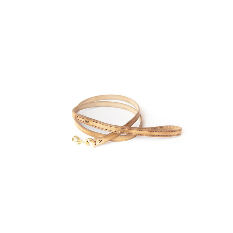 Tan full-grain leather dog leash laid flat with brass snap hook and metal ring