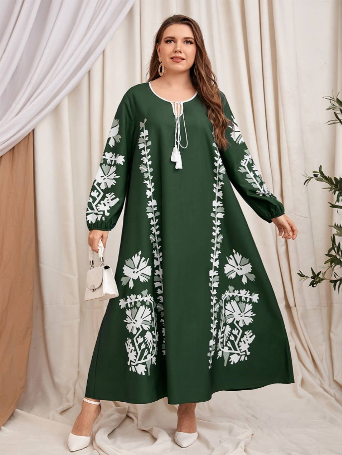 Dark green A-line maxi dress with white floral print, long sleeves, tassel neck detail