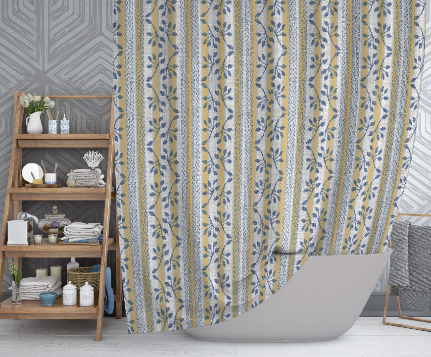 Floral stripe shower curtain draped beside a bathtub, blue and yellow leaf design