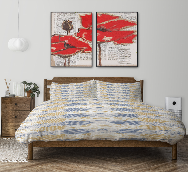 Comforter set on bed with blue-and-yellow abstract print and two matching shams