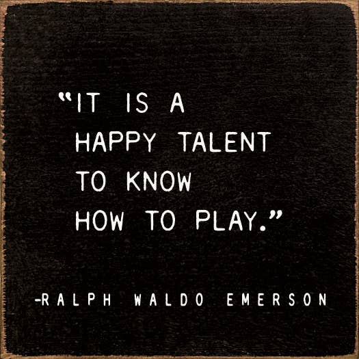 Dark square quote print with white text: “It is a happy talent to know how to play.”