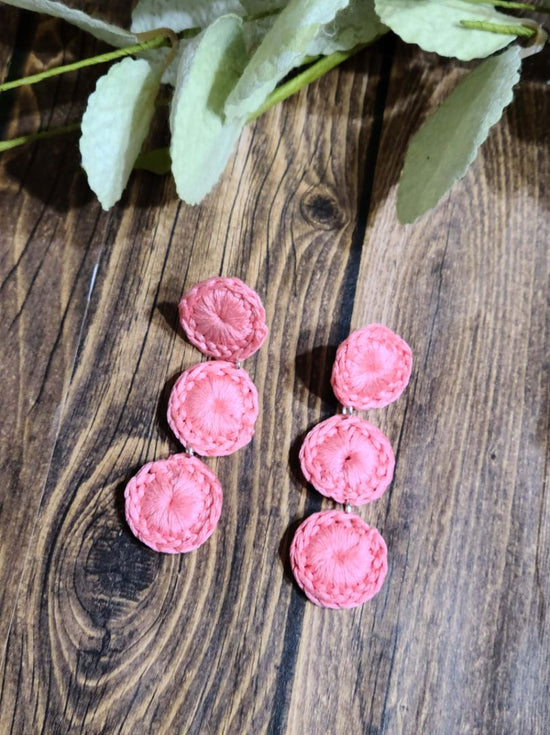 Pink fabric-textured circle drop earrings with three dangling discs