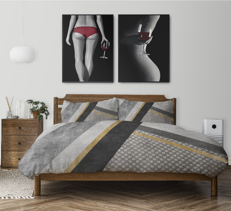 Multicolor comforter set on bed with gray, black, and gold geometric stripe pattern and pillow shams