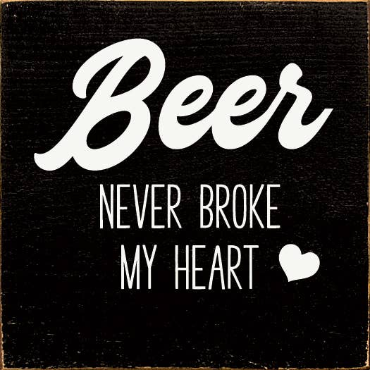 Black beer wall art with white "Beer Never Broke My Heart" text and heart