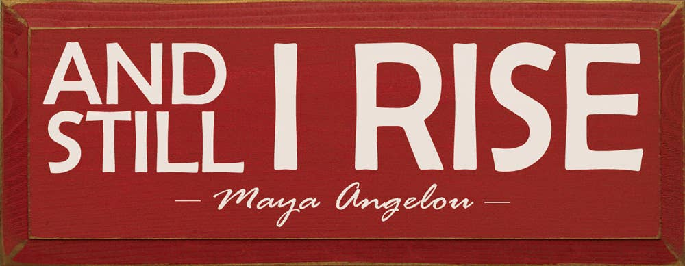 Red wood sign with "AND STILL I RISE" and "Maya Angelou" text