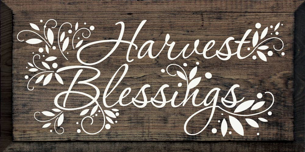 Rustic wooden wall sign with white script “Harvest Blessings”