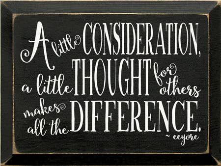 Dark wood sign with white quote text: “A little consideration…” and “…difference.”
