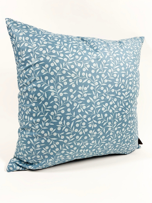 Teal square throw pillow with white leaf pattern, visible side and corner seams