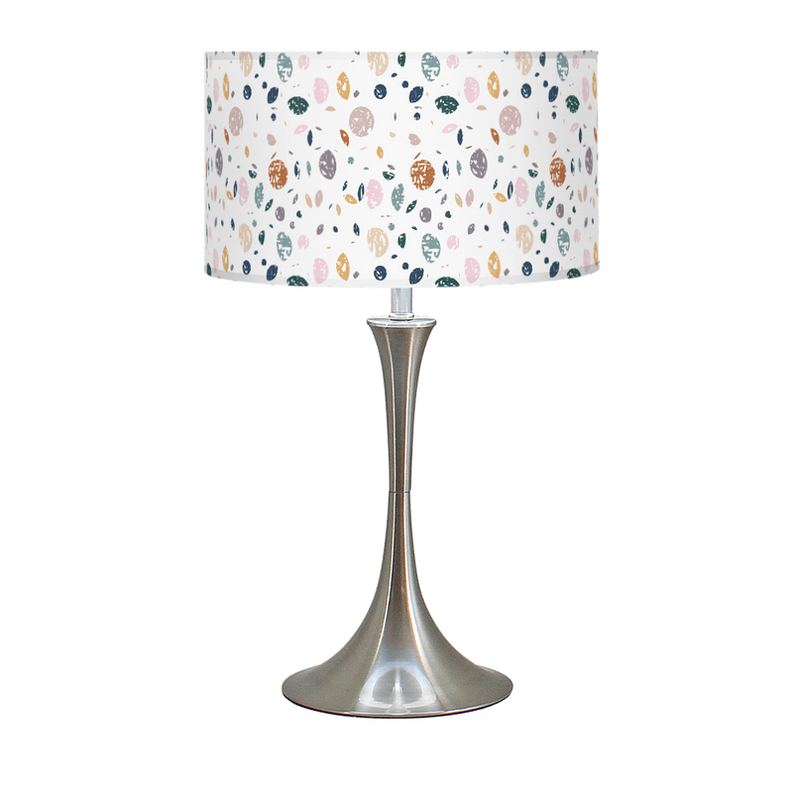 Table lamp with white patterned drum shade and silver pedestal base