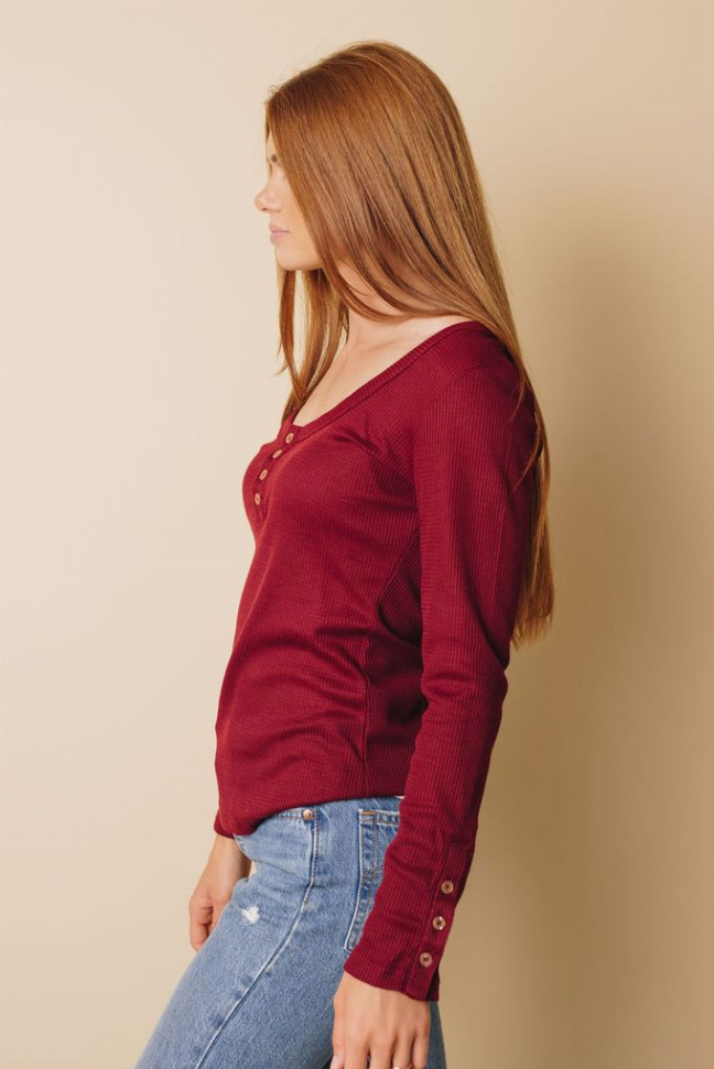 Burgundy long-sleeve button top with cuff buttons and scoop neckline, side view