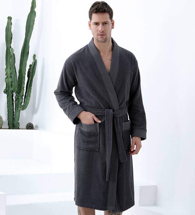 Men's charcoal terry kimono bathrobe with belt tie and two front pockets, one hand in pocket
