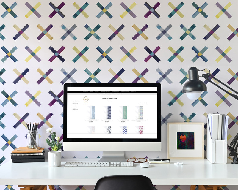Geometric peel-and-stick wallpaper with colorful X motif behind desk setup