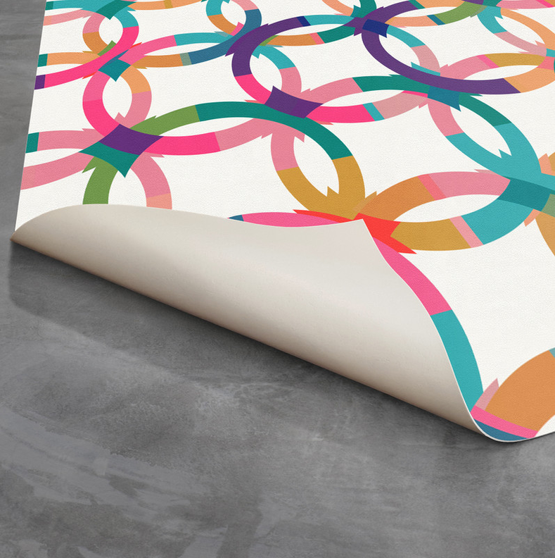 Geometric loop rug with multicolor top and light backing, rolled corner