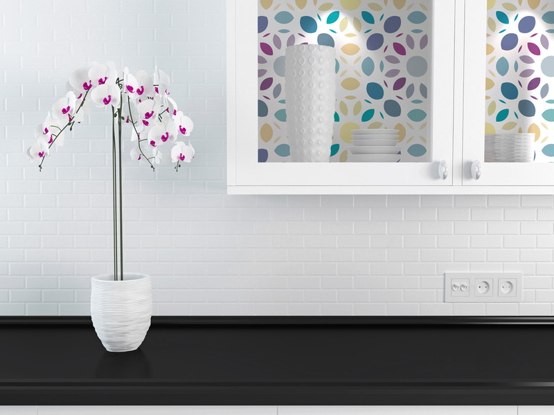 Peel-and-stick wallpaper with multi-color mosaic leaf pattern in blue, purple, and yellow.