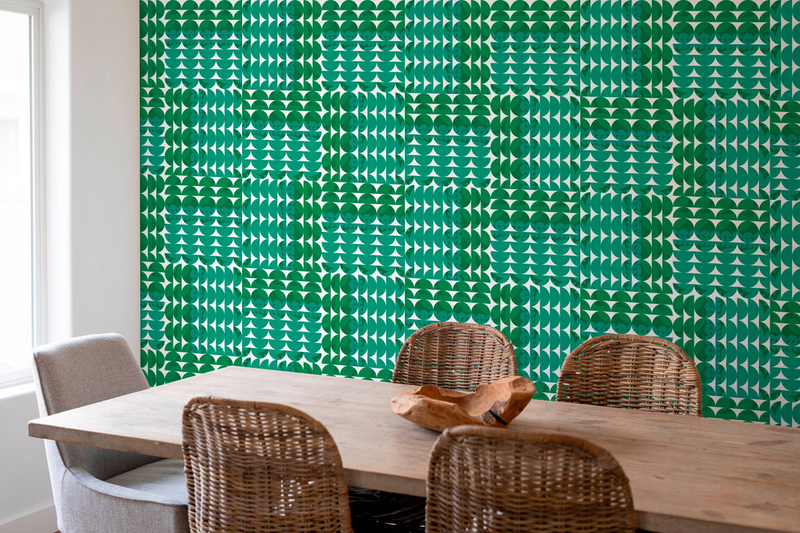 Green geometric peel-and-stick wallpaper panel with repeating circle motif on room wall.