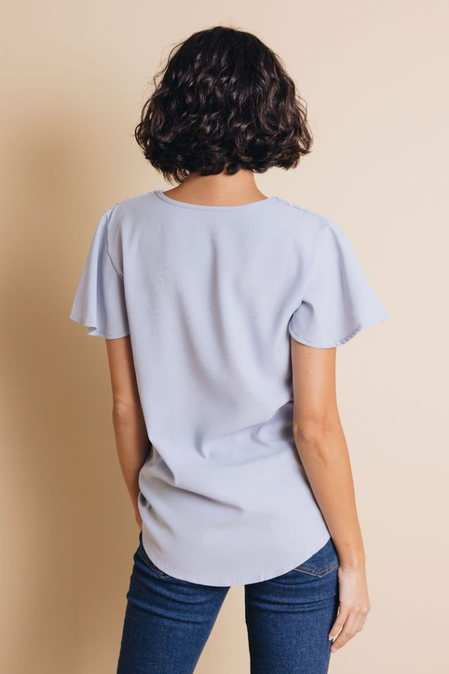 Light blue short-sleeve V-neck blouse, back view with flutter sleeves