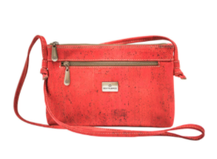 Red cork crossbody bag with zip-top, front logo plate, and adjustable shoulder strap