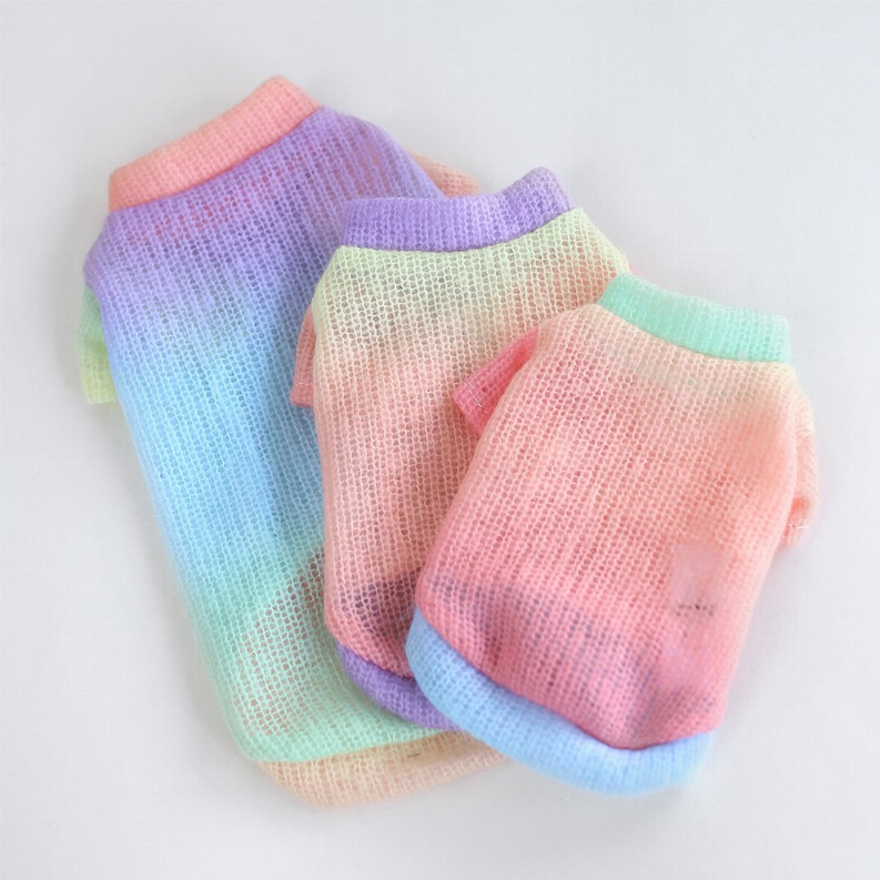 Pastel rainbow knit sweaters, folded and stacked with ribbed cuffs