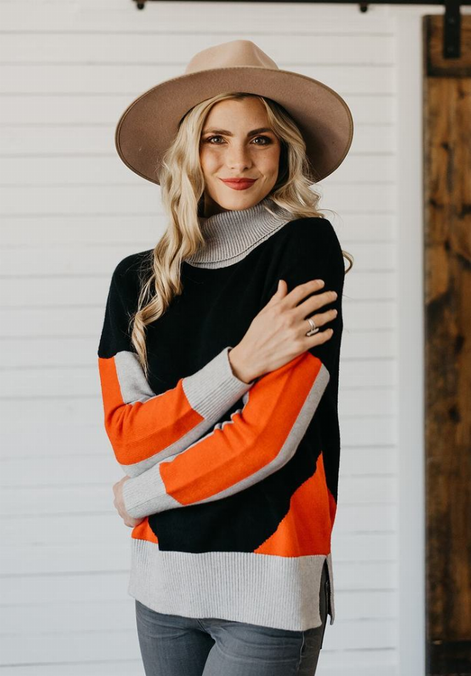 Women's color-block turtleneck sweater, black with orange panels and gray ribbed cuffs