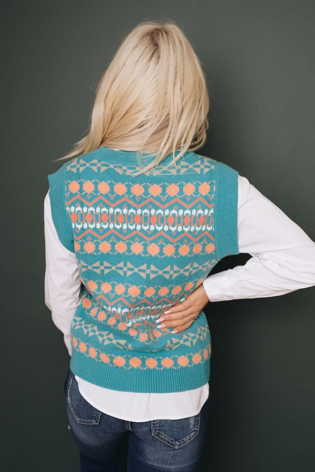 Back view of teal tribal print knitted sweater vest with v-neck and orange cream pattern