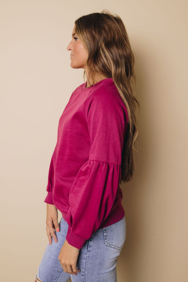 Magenta balloon-sleeve crewneck sweatshirt, side profile with relaxed pullover fit