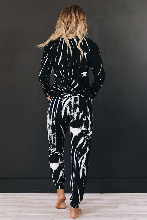 Back view: black two-piece loungewear set with hooded top and jogger pants, white splatter